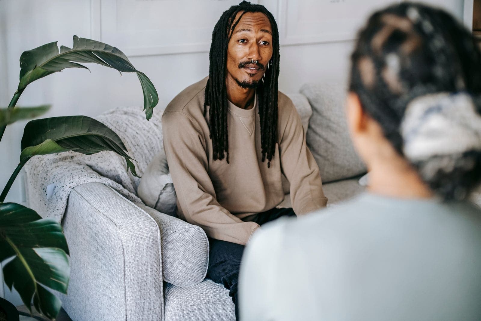 A support worker talking with a man on a sofa in a bright living room